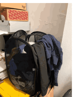 Clothes hung over the edge of a mesh hamper