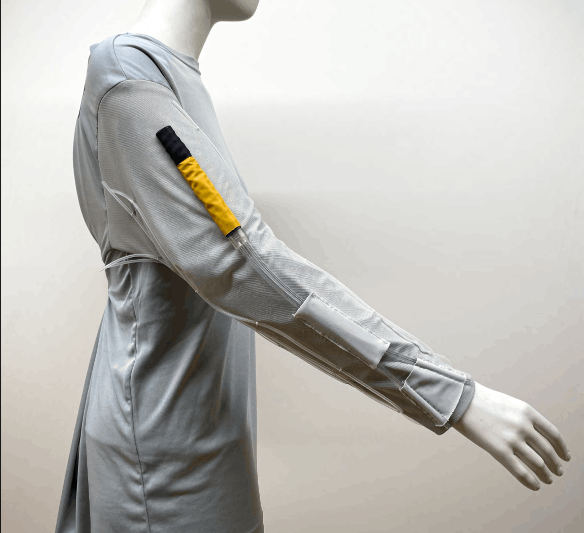 LCVG prototype garment on a mannequin with yellow vent duct on the upper arm and extension sleeve running to the wrist