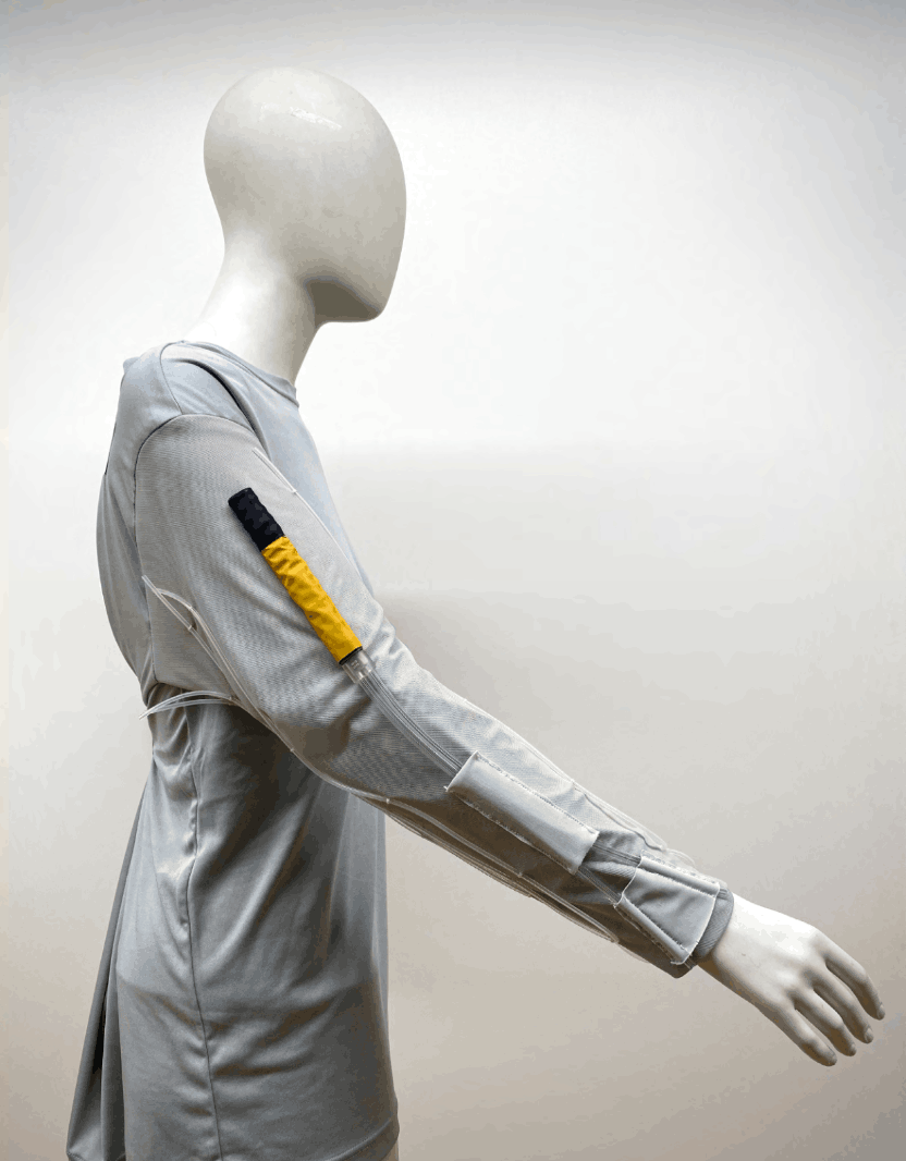Final LCVG vent duct extension sleeve prototype on a mannequin, with yellow duct and low-profile tube holders along the arm