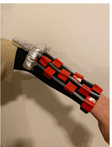 Prototype 1: flexible fabric sleeve with red 3D-printed clips and an elbow cuff holding the connector and tubes