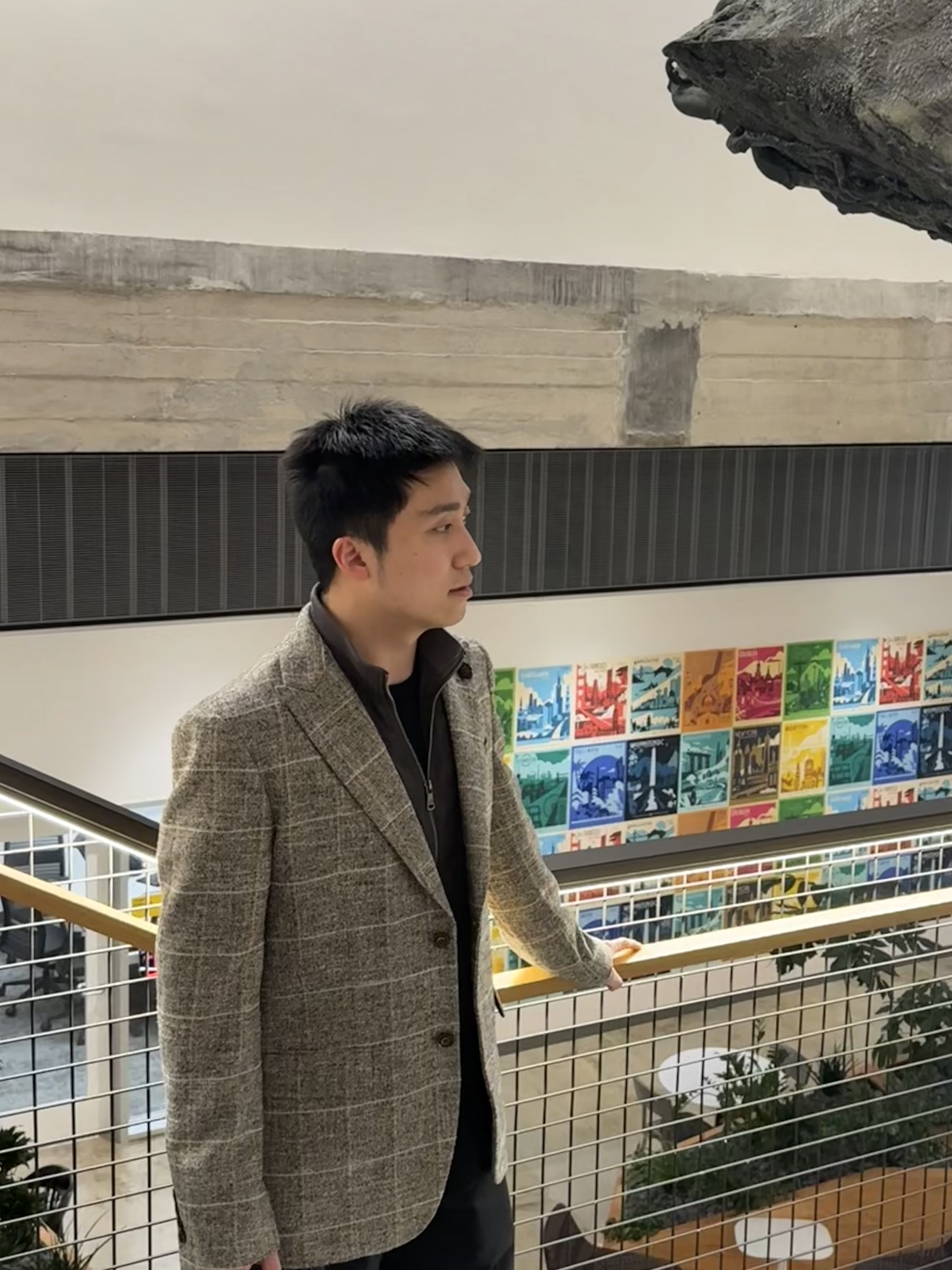 Chenwei Lin in a gray blazer beside a museum railing